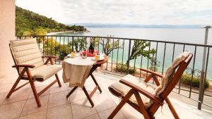 洛夫兰Apartment Villa Lidija的阳台配有桌椅,享有水景。