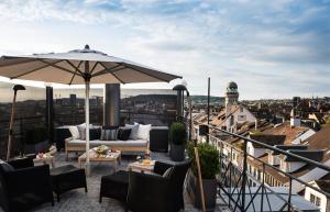 苏黎世Widder Hotel - Zurichs luxury hideaway的阳台的天井配有沙发和遮阳伞