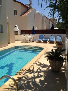 普罗塔拉斯马里海岸别墅酒店的一个带椅子的游泳池以及一座房子