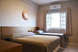 巴拉奈里奥-坎布里乌CASA PRAIA A 600m DO MAR的一间卧室设有两张床和窗户。