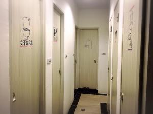 高雄七桃公寓的走廊上设有四扇门,墙上挂着画