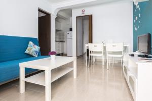 科斯塔卡玛8202 - Wifi Costa Calma Bungalow的客厅配有蓝色的沙发和白色的桌椅