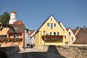 哈尔堡Hotel Gasthof zum Goldenen Lamm的镇上一条街道,有黄色的房子和钟楼