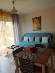 洛涅芦苇丛中公寓的客厅配有蓝色的沙发和桌子