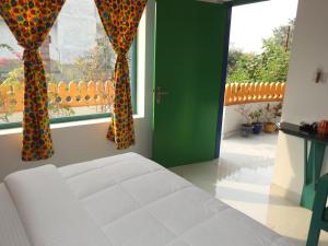 阿格拉Coral Country Homestay的一间卧室配有床和两个带窗帘的窗户