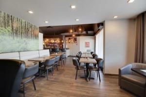 七岛市旅行者酒店的用餐室配有木桌和椅子