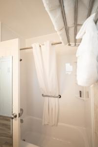 威尼斯Island Sun Inn & Suites - Venice, Florida Historic Downtown & Beach Getaway的带淋浴和白色毛巾的浴室