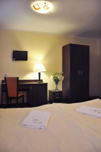 什切齐内克波折兹尔则酒店的配有一张床、一张桌子和一张桌子的酒店客房