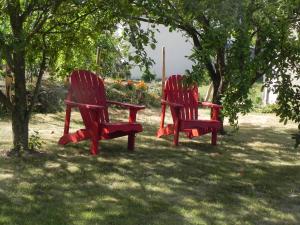 武夫赖Les Patis的两把红色椅子坐在树下的草地上