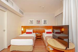 圣保罗Slaviero São Paulo Moema的一间酒店客房,设有两张床和电视