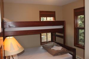 太阳峰Woodhaven # 8 in Sun Peaks的配有一张双层床的带灯和窗户的房间