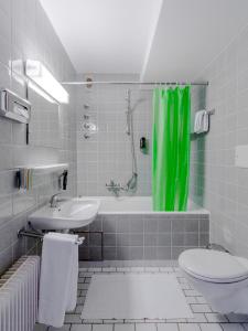 普海姆帕尔斯贝里酒店的一间带绿色淋浴帘和卫生间的浴室
