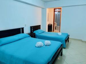 瓜塔佩VIVIENDA TURÍSTICA EL ZÓCALO的配有镜子的客房内的两张床和蓝色床单