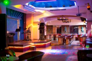 伊斯塔帕Barceló Ixtapa - All Inclusive的一间设有吧台的房间,配有桌子和舞台