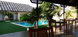 邦劳HIGALA度假村的一个带桌椅的庭院和一个游泳池