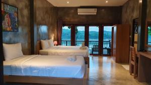 清刊Chiang Klong Riverside Resort的酒店客房设有两张床和一个阳台。