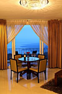 大雅台塔盖泰湖景酒店的一间带桌椅和大窗户的用餐室