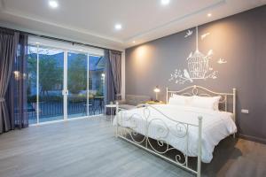 北冲Baan Phurit Khaoyai的卧室配有一张挂在墙上的吊灯床。