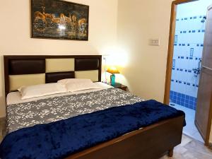 贾巴尔普尔Aditya Premium HomeStay- Furnished Air Conditioned- 2BHK的一间卧室配有一张带蓝色棉被的床