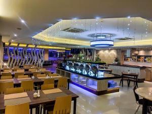 Tanjungredep大帕拉玛酒店的一间带桌椅的餐厅和一间酒吧