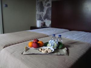 韦拉斯Casa da Ermida的床上的水果和水瓶托盘