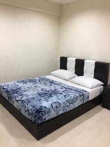 瓜埠langkawi homestay murah kawasan bandar的一间卧室配有一张带蓝白色毯子的床