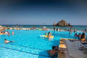 艾阿卡Sandy Beach Hotel & Resort的一群人在海滩的游泳池里