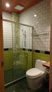 花莲市巴斯特先生民宿 的一间带卫生间和玻璃淋浴间的浴室