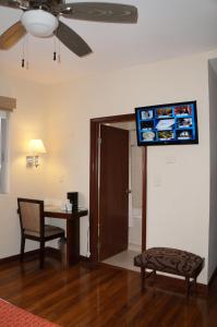 奇瓦瓦奇瓦瓦广场酒店的客厅配有桌子和墙上的电视