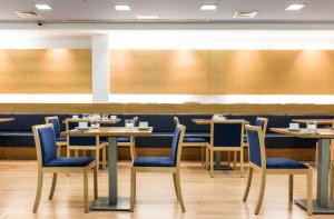 圣卡洛斯拉腊皮塔港口酒店的一间配备有桌子和蓝色椅子的用餐室