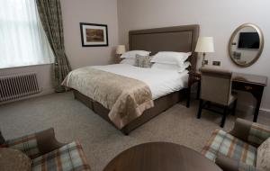 鲍内斯温德米尔麦克唐纳德老英格兰酒店&SPA的酒店客房带一张床、一张桌子和椅子