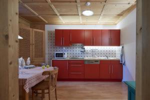 圣坎迪朵克里斯蒂娜别墅酒店的一间厨房,配有红色橱柜和一张桌子