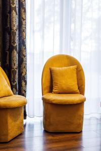 科沙林Gold Rooms的靠窗边带枕头的黄色椅子