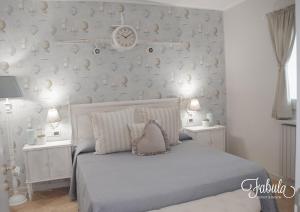 莫诺波利Masseria Fabula Bistrot & Maison的卧室配有一张挂在墙上的带时钟的床
