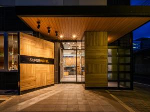 松本松本天然温泉超级酒店的木门商店的入口