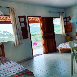 伊比科阿拉Pousada Serra Aquarela - Mini casas的一间设有门的房间,可通往带窗户的卧室