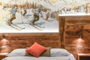 萨奥兹-杜尔克斯情缘酒店的卧室的墙上挂着滑雪者的绘画作品
