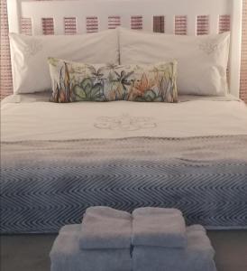 比勒陀利亚Garsfontein Bed and Breakfast的一张带两个枕头的床和两条毛巾