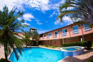 布希奥斯Pousada Marbella的一个带游泳池和棕榈树的度假村