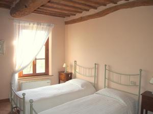 锡耶纳Nell'Antica Torre di Fronte a Siena的卧室设有两张床,带窗户