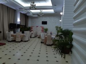 BîrladHotel Ro&Mario Barlad的宴会厅配有白色的桌椅和电视
