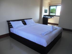 清莱扬苏帕库特酒店的一间卧室配有一张带白色床单的大床