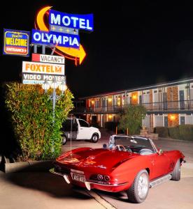 昆比恩奥林匹亚汽车旅馆的停在汽车旅馆前的红色汽车