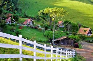 蒙特韦尔迪Chalés Fazenda Vale da Mata的房屋前的白色围栏