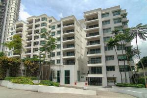 吉隆坡韦奇伍德公寓的一座白色的大建筑,前面有棕榈树