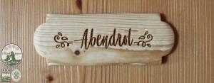 蒙德塞Kinderparadies Bachbauer的木墙上的标志,上面写着