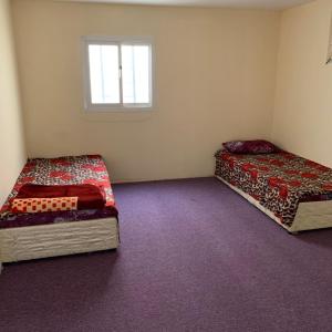 穆哈伊犁Alkithri Apartments for Singls的小型客房 - 带2张床和窗户