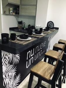 里奥阿查Nueve Uno Hostel的厨房配有带椅子的柜台和台面