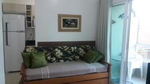 弗洛里亚诺波利斯Lindo Apto, 50metros do mar, Ideal Para Familias的客厅配有带绿色枕头的沙发