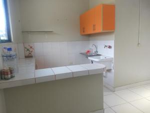 塔拉波托Departamento Melly的白色的厨房配有橙色橱柜和水槽